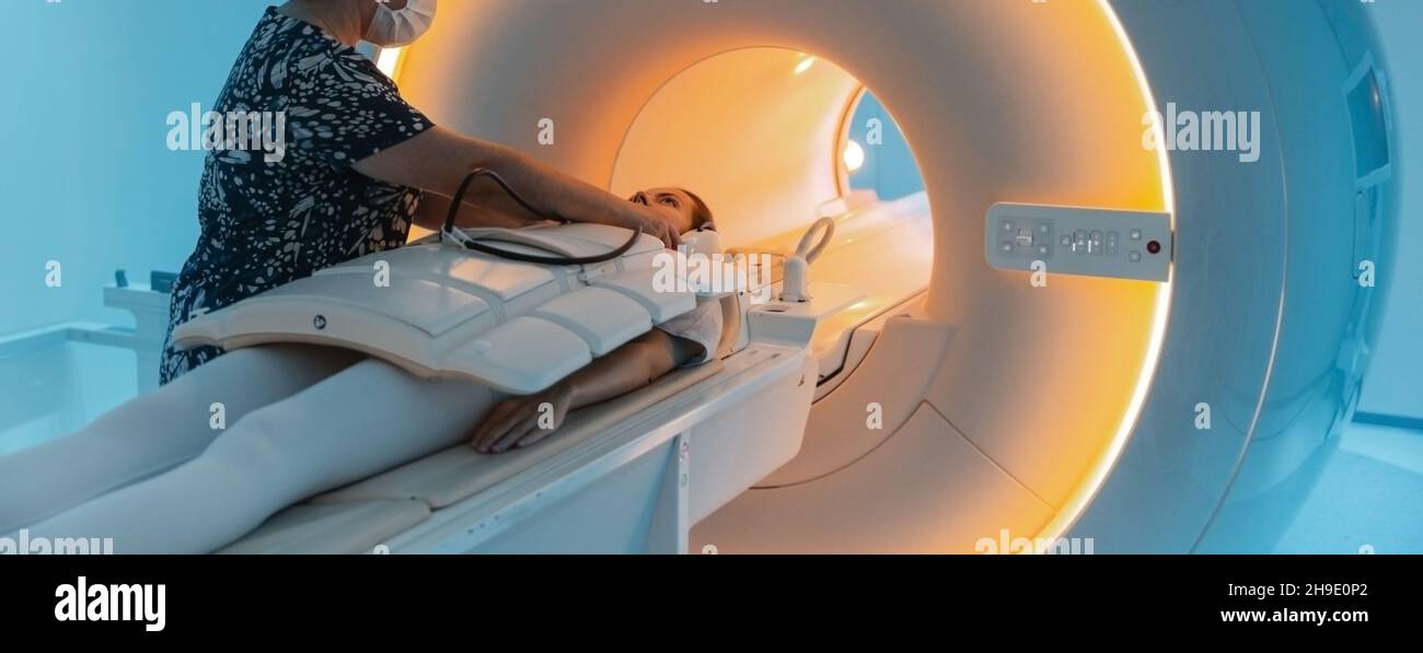 Doctor or nurse and patient with tomography CT or MRI Scan in hospital. Interior of radiography department. Technologically advanced equipment in Stock Photo