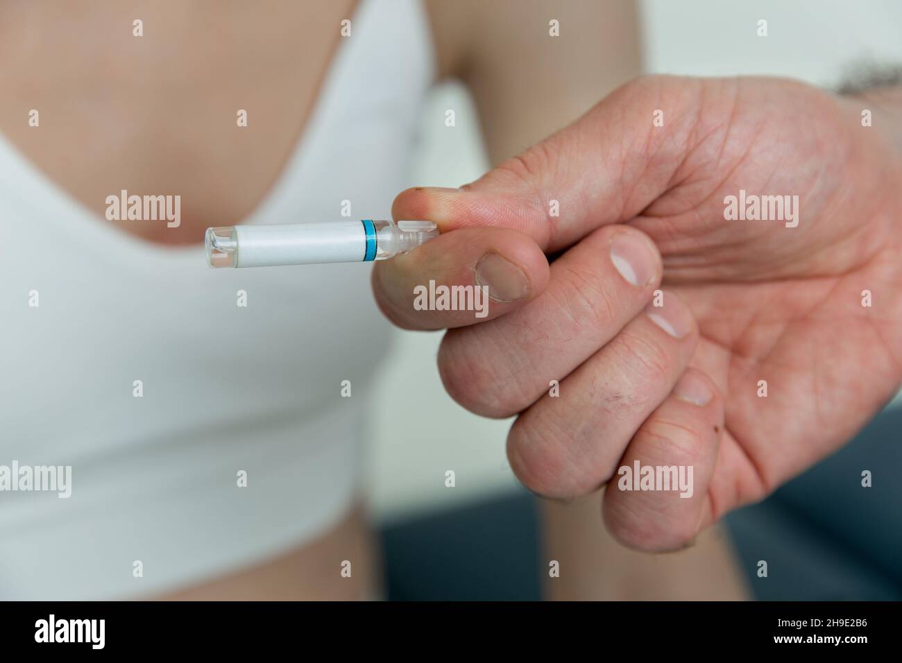 Doctor holds in hands small ampoules. Close up of small ampoule with a vaccine in the doctor hand. Holding test tube for allergy test. Allergy Testing Stock Photo