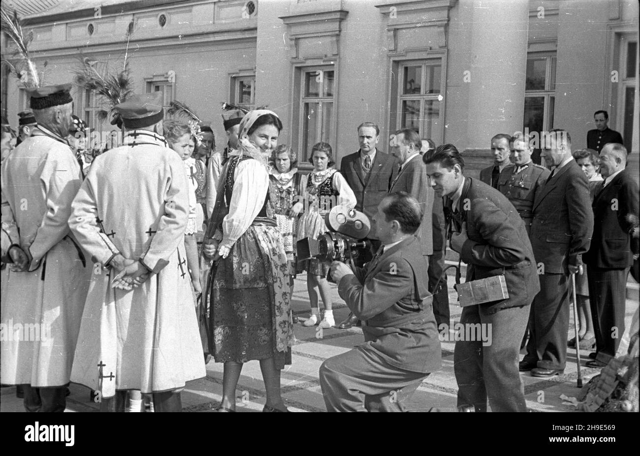 Warszawa, 1947-10-09. Delegacja do¿ynkowa krakowiaków i górali z wizyt¹ u prezydenta Boles³awa Bieruta w Belwederze. Nz. prezydent Bierut (z w¹sami, C) i goœcie przed Belwederem oraz ekipa Polskiej Kroniki Filmowej: W³adys³aw Forbert (z kamer¹). wb/gr  PAP      Warsaw, Oct. 9, 1947. A harvest festival delegation of Cracovians and highlanders visits President Boleslaw Bierut in Belvedere Palace. Pictured: President Bierut (moustached, centre) and guest in front of the palce, and Polish Newsreel team, cameraman Wladyslaw Forbert (with a camera).  wb/gr  PAP Stock Photo