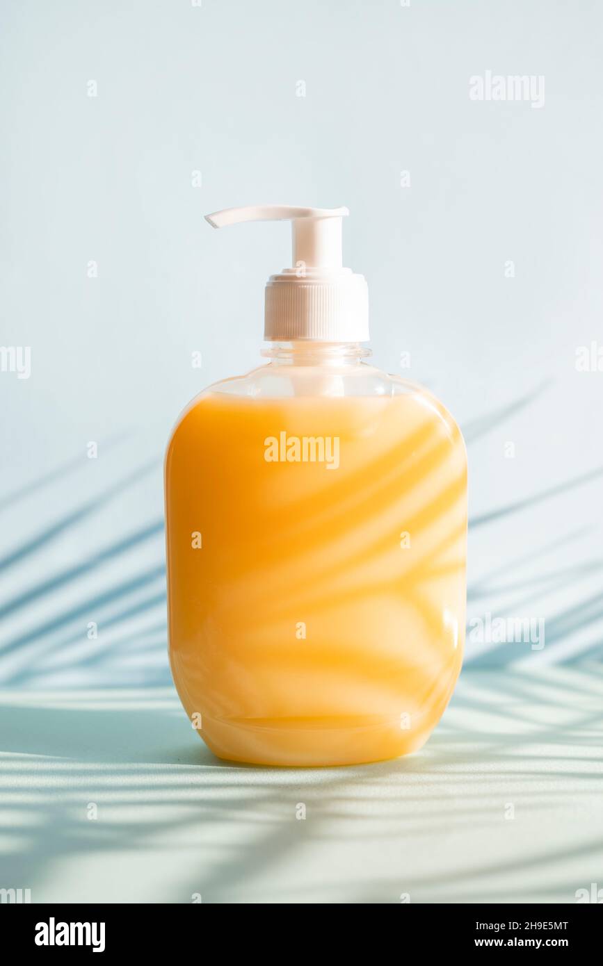 liquid soap in a bottle with a dispenser on a palm tree background