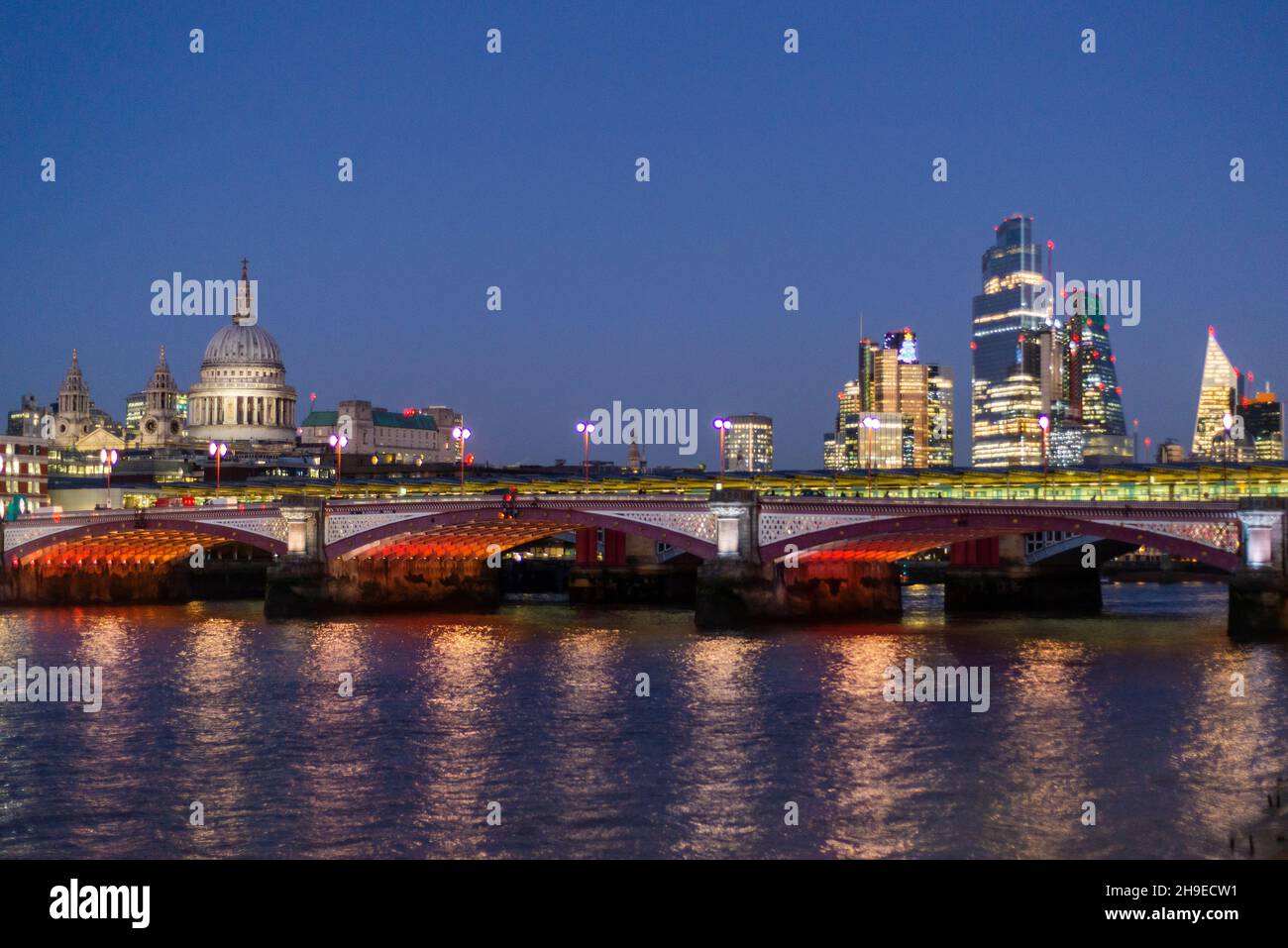 Blackfriars Bridge lit at night and St Pauls cathedral and Square Mile buildings, London, England, UK Stock Photo