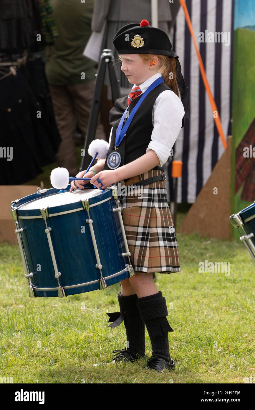 A young drummer in a Highland pipe band with her tenor drum in a Scottish festival in Utah. Stock Photo