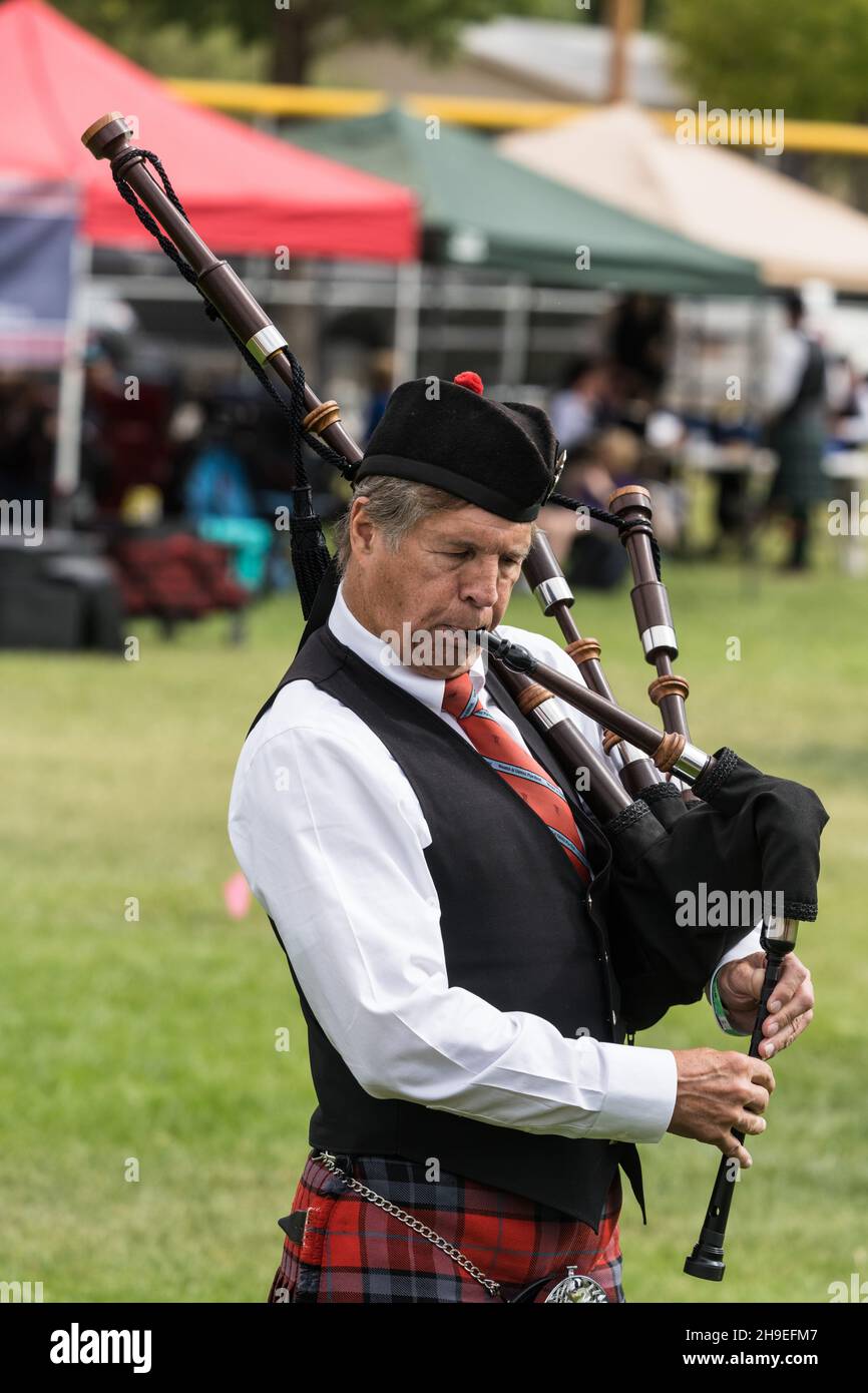 A bagpiper in full regalia plays the Great HIghland bagpipes at a Scottish festival in Moab, Utah. Stock Photo