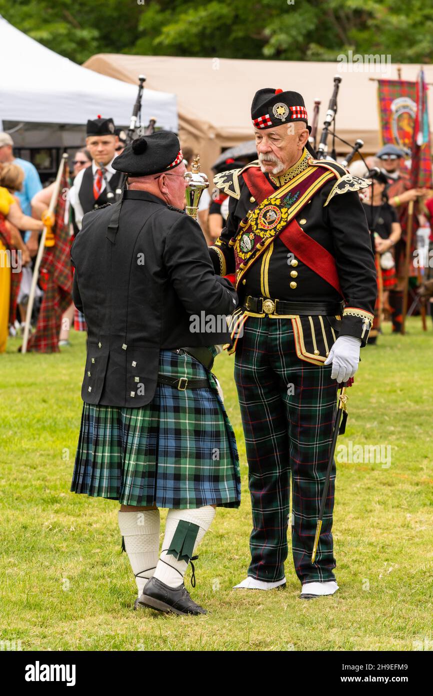 A Highland drum major in full regalia talks to a man in full kilt and tam 'o shanter at a Scottish festival in Utah, USA. Stock Photo