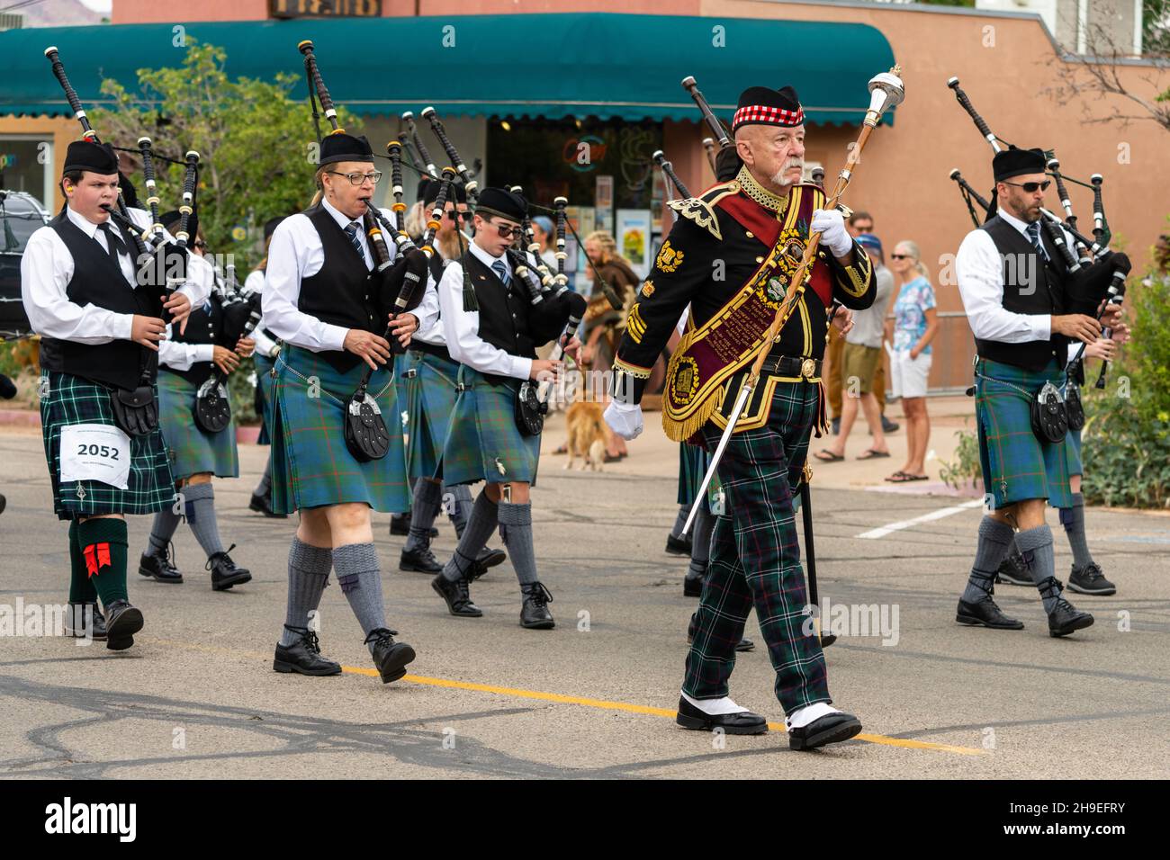 A Highland drum major in full regalia with his mace leads a pipe band