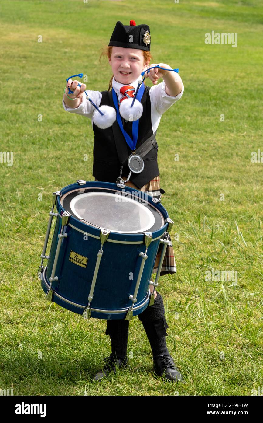 A drummer in a Highland Scottish pipe band flourishes or twirls her drumsticks  at a Scottish festival in Utah. Stock Photo