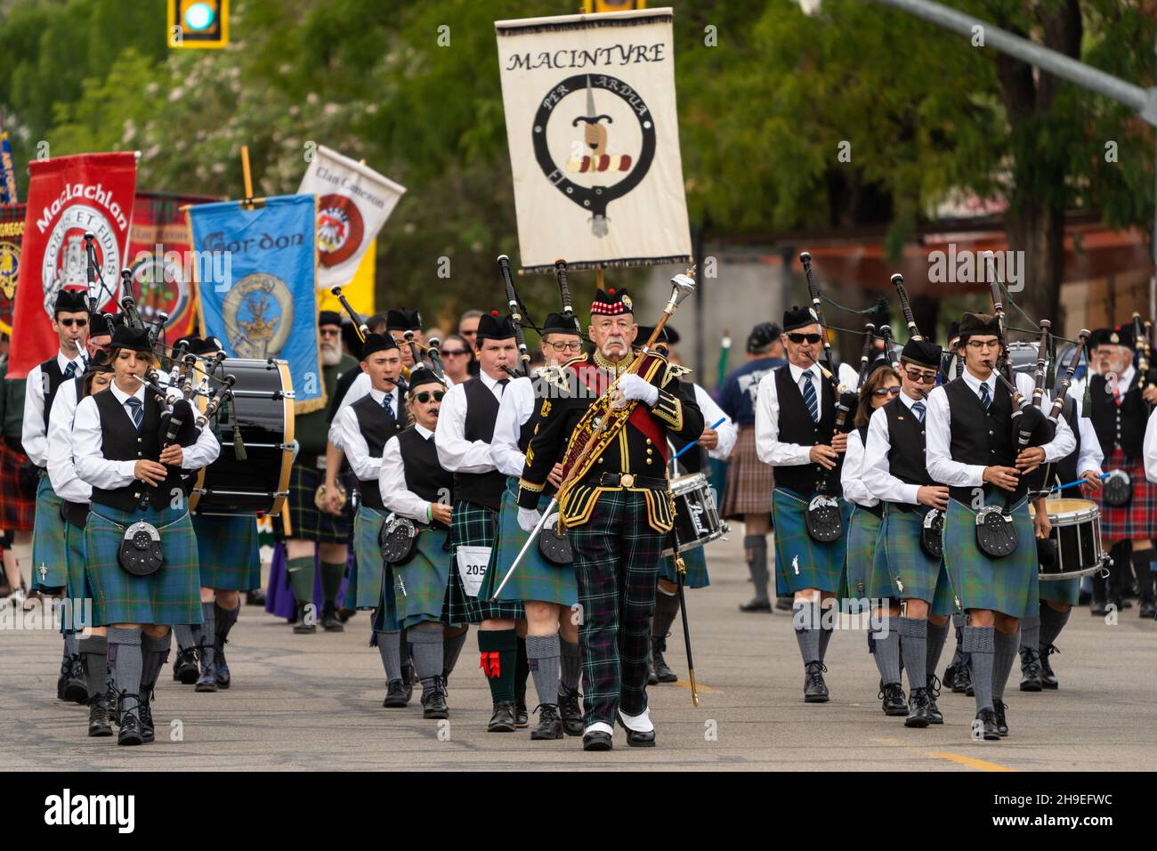 A Highland drum major in full regalia with his mace leads a pipe band