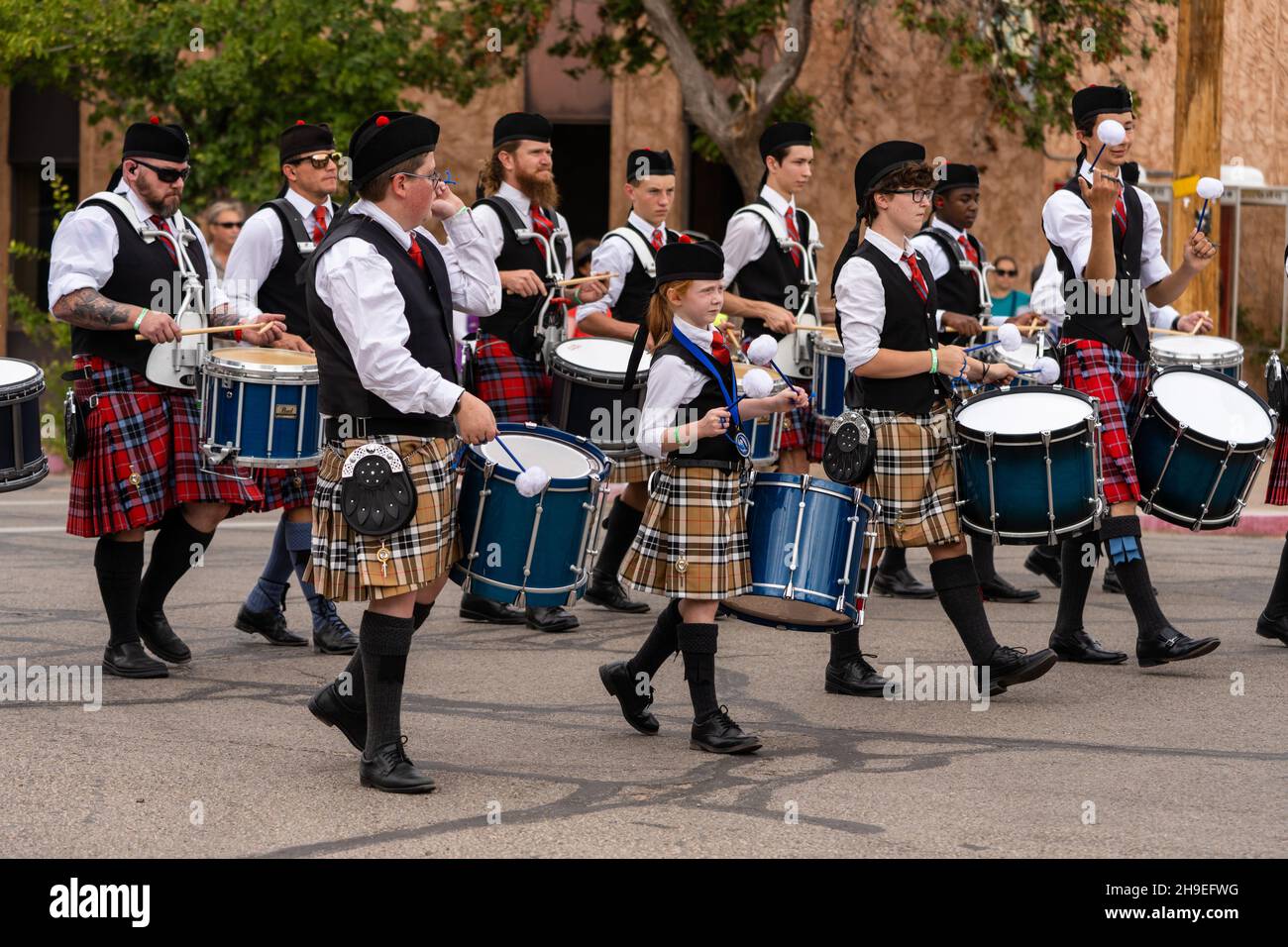 Drummers in a Highland Scottish bagpipe band marching in a parade at a