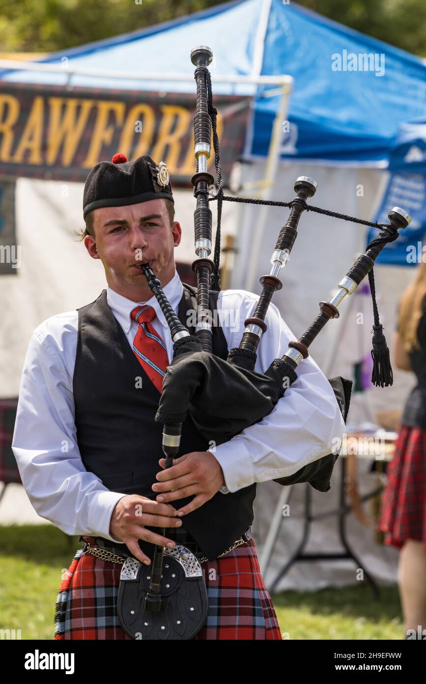 A bagpiper in full regalia plays the Great HIghland bagpipes at a Scottish festival in Moab, Utah. Stock Photo