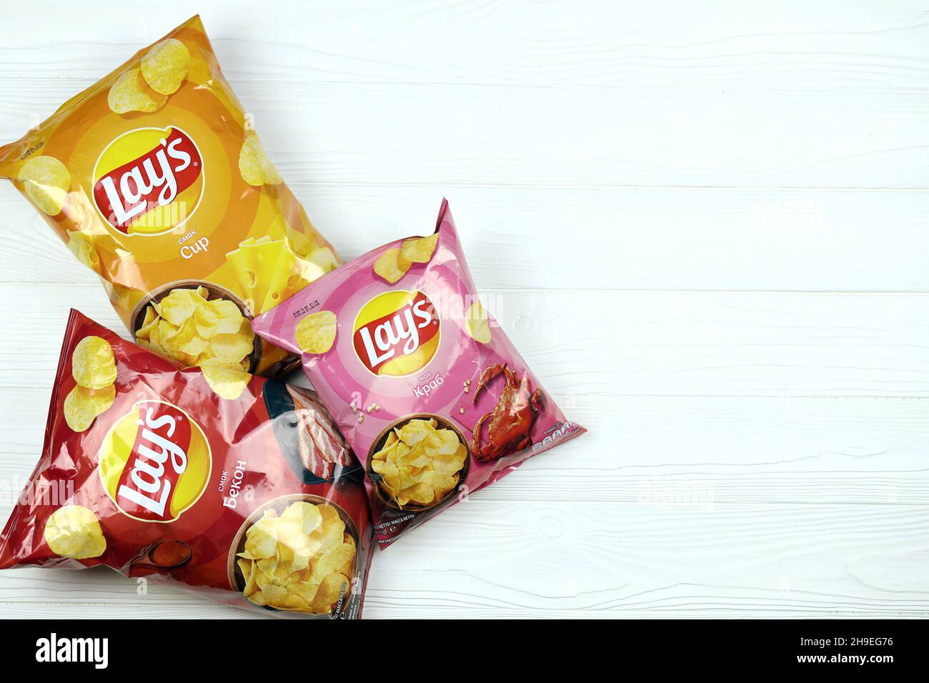 KHARKOV, UKRAINE JANUARY 3, 2021 Various flavoured of lay's potato chips on wooden background