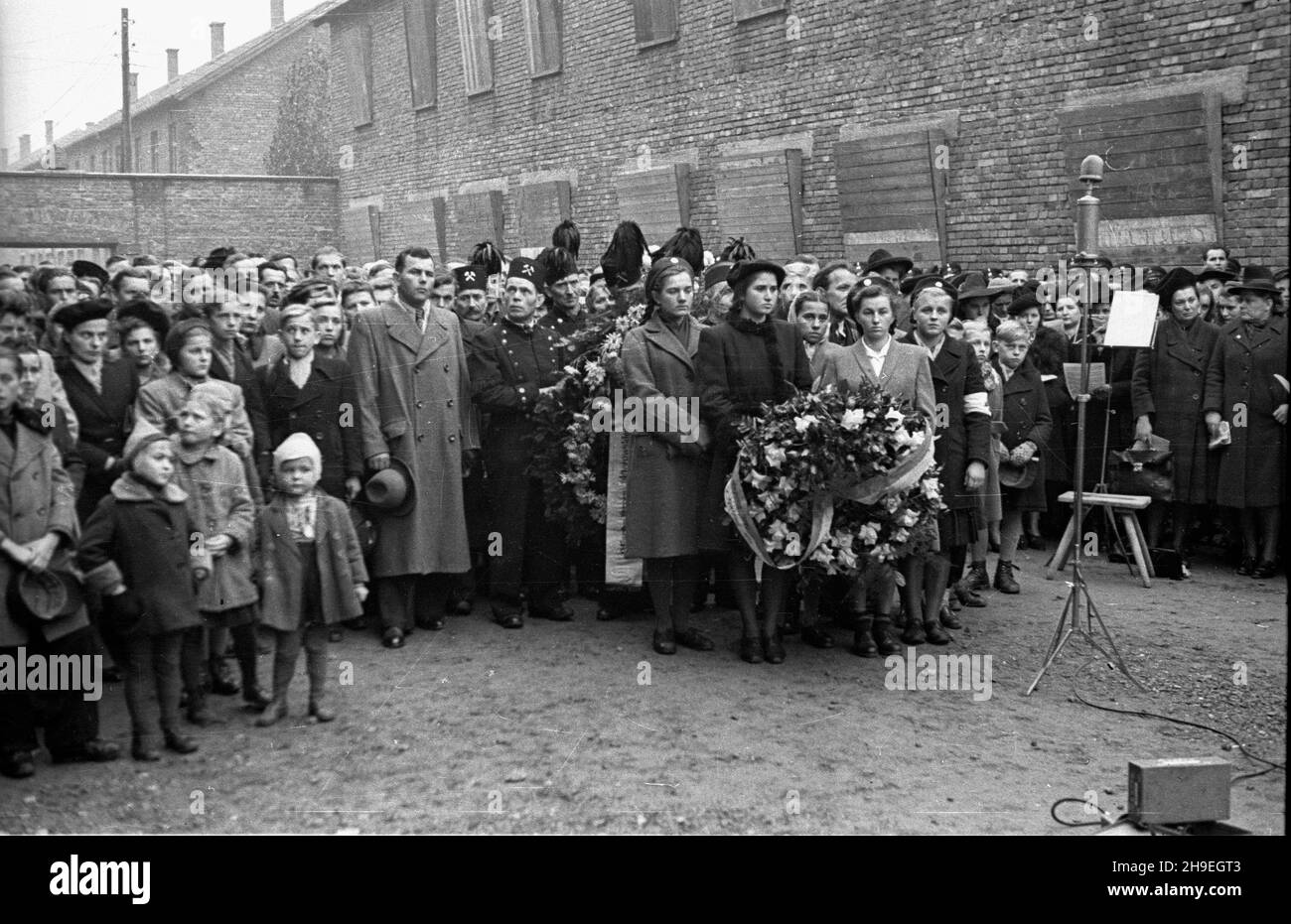 Oœwiêcim, 1947-11-01. By³y niemiecki obóz koncentracyjny Auschwitz-Birkenau. Nz. uroczystoœæ z³o¿enia wieñców przed œcian¹ œmierci na dziedziñcu bloku XI, gdzie dokonywano egzekucji. ps/gr  PAP      Oswiecim, Nov. 1, 1947. Former concentration camp Auschwitz-Birkenau. Pictured: a wreath laying ceremony at the death wall, the execution site, on the yard of the 11th block.  ps/gr  PAP Stock Photo