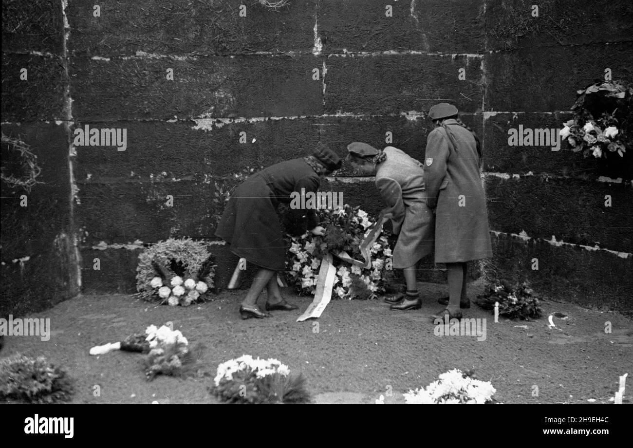 Oœwiêcim, 1947-11-01. By³y niemiecki obóz koncentracyjny Auschwitz-Birkenau. Nz. kobiety sk³adaj¹ wieniec przy œcianie œmierci na dziedziñcu bloku XI, gdzie dokonywano egzekucji. ps/gr  PAP      Oswiecim, Nov. 1, 1947. Former concentration camp Auschwitz-Birkenau. Pictured: women laying flowers at the death wall, the execution site, on the yard of the 11th block.  ps/gr  PAP Stock Photo