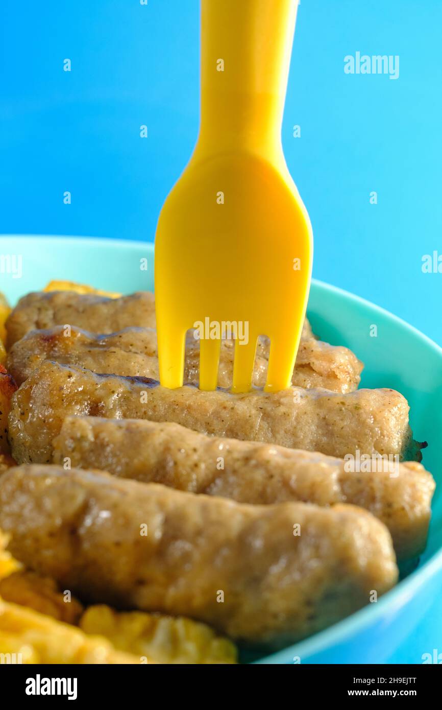 Closeup macro breakfast sausage with plastic utensils as fun kids