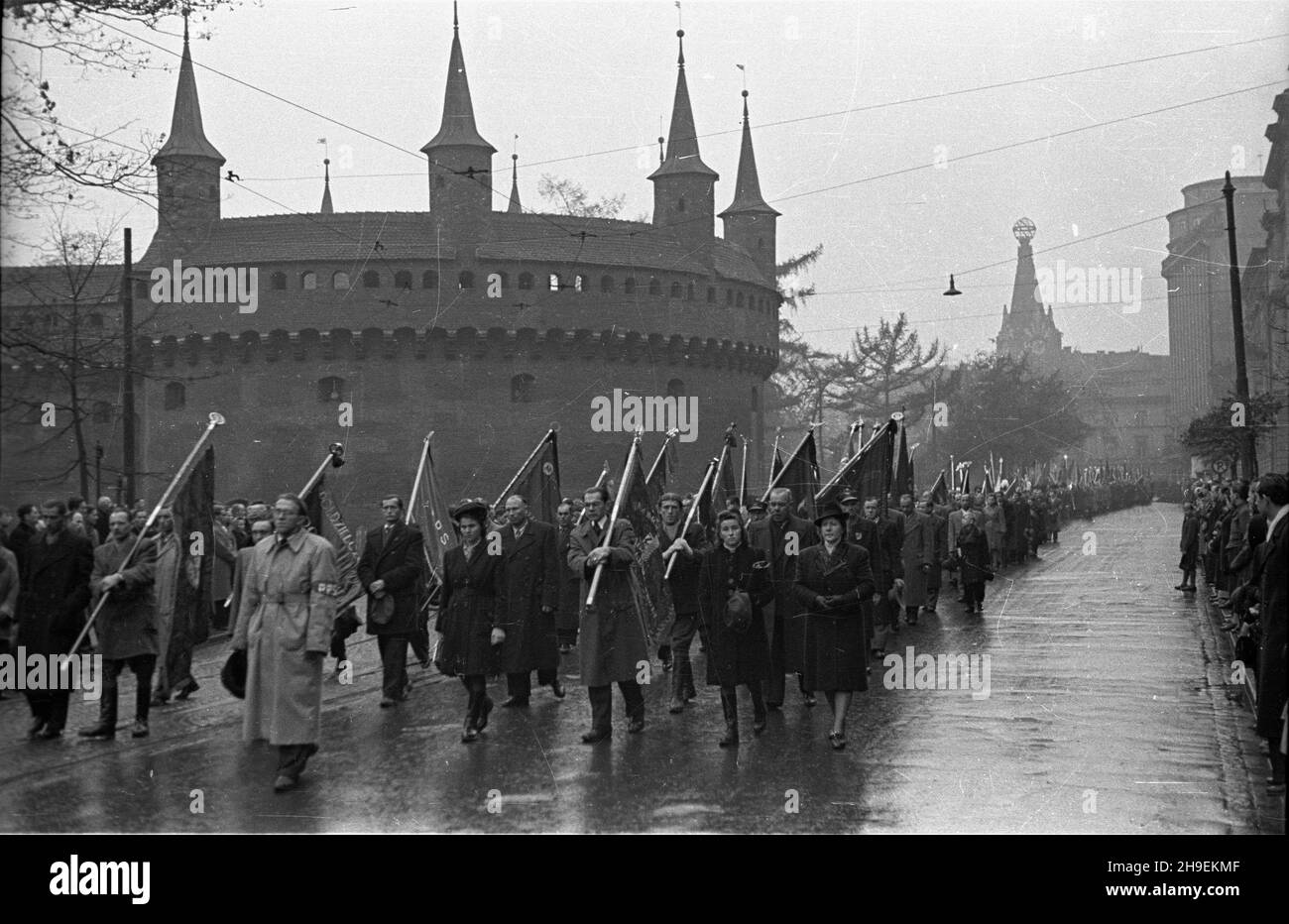 Kraków, 1947-11-02. Obchody jedenastej rocznicy œmierci przywódcy Polskiej Partii Socjalistycznej Ignacego Daszyñskiego. Nz. przemarsz uczestników uroczystoœci ulicami miasta na cmentarz Rakowicki. W g³êbi z lewej barbakan (zwany potocznie Rondlem). ps/gr  PAP      Cracow, Nov. 2, 1947. Commemorations of the 11th death anniversary of Polish Socialist Party leader Ignacy Daszynski. Pictured: participants in the ceremony heading towards the Rakowicki cemetery. In the background the barbican.  ps/gr  PAP Stock Photo