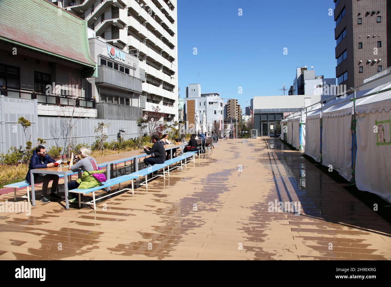 On the rooftop of one of the outer seafood markets in Toky's Tsukiji district where customers are able to eat outdoors at provided tables and benches. Stock Photo