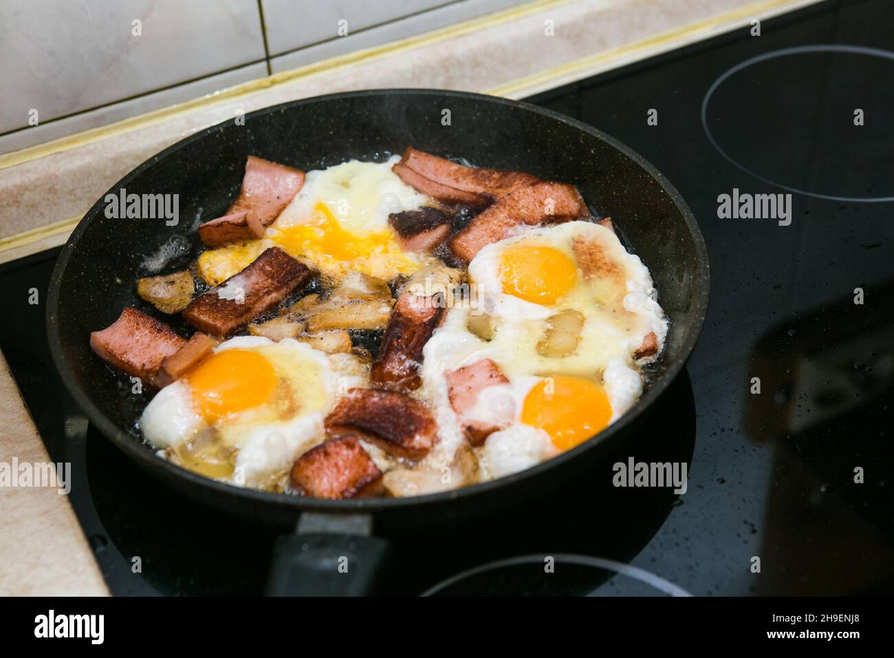 The process of cooking scrambled eggs with lard and sausage. The man