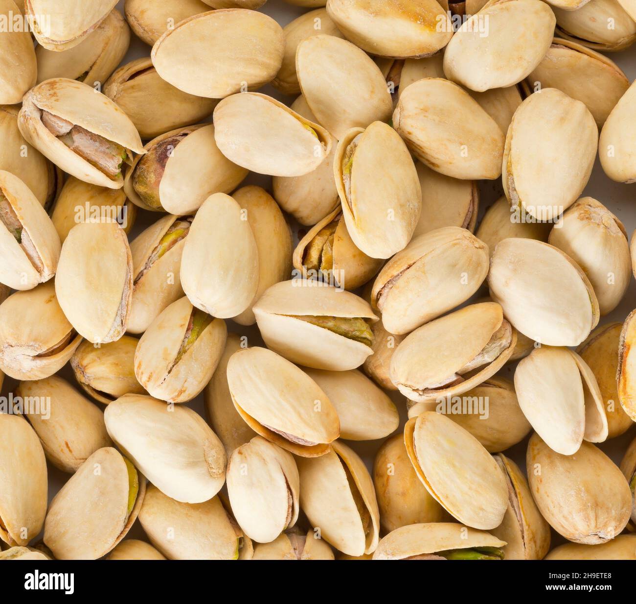 Salted, roasted green pistachio nuts snack, healthy food snack, flat lay top view from above Stock Photo