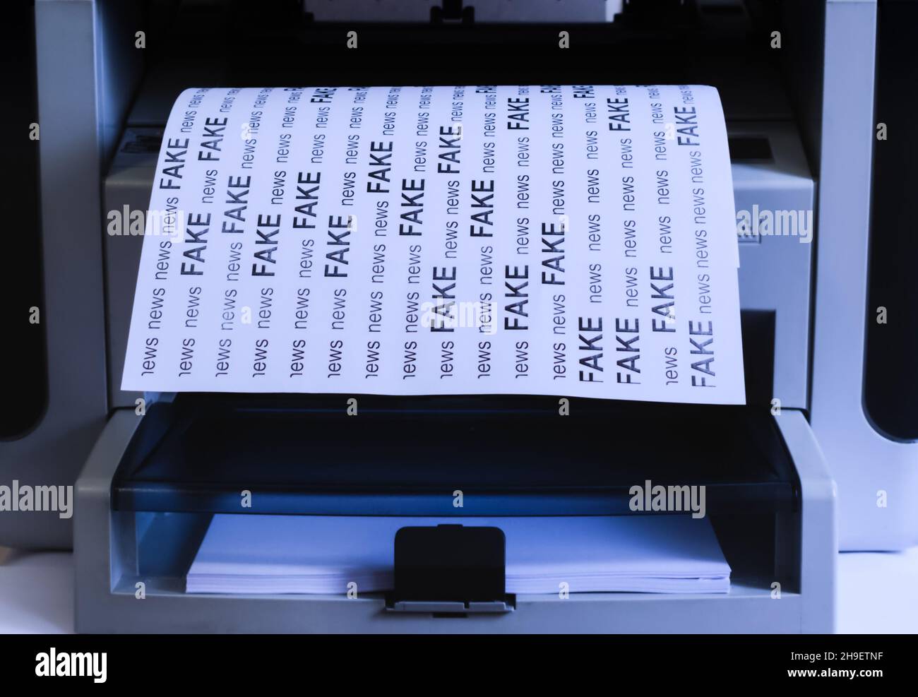 White sheet of paper with text - FAKE NEWS - printed on printer Stock Photo