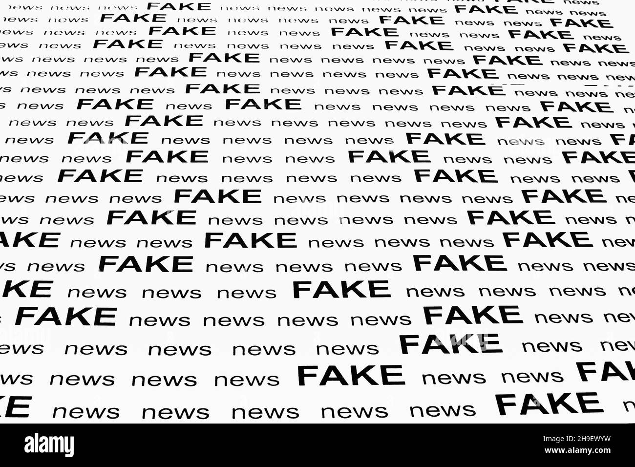 Text - FAKE news - printed on white sheet of paper in black and white Stock Photo