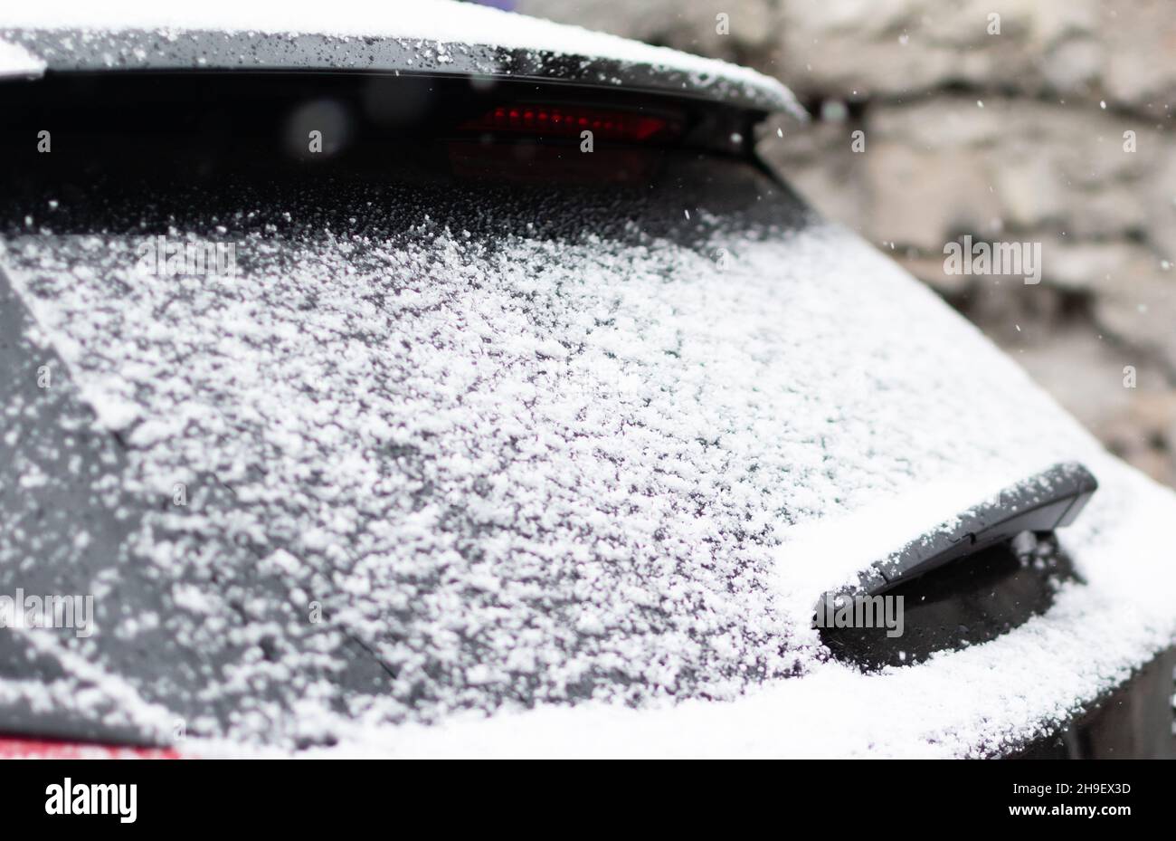 White snow on rear car window in winter time. Focus in the center of ...