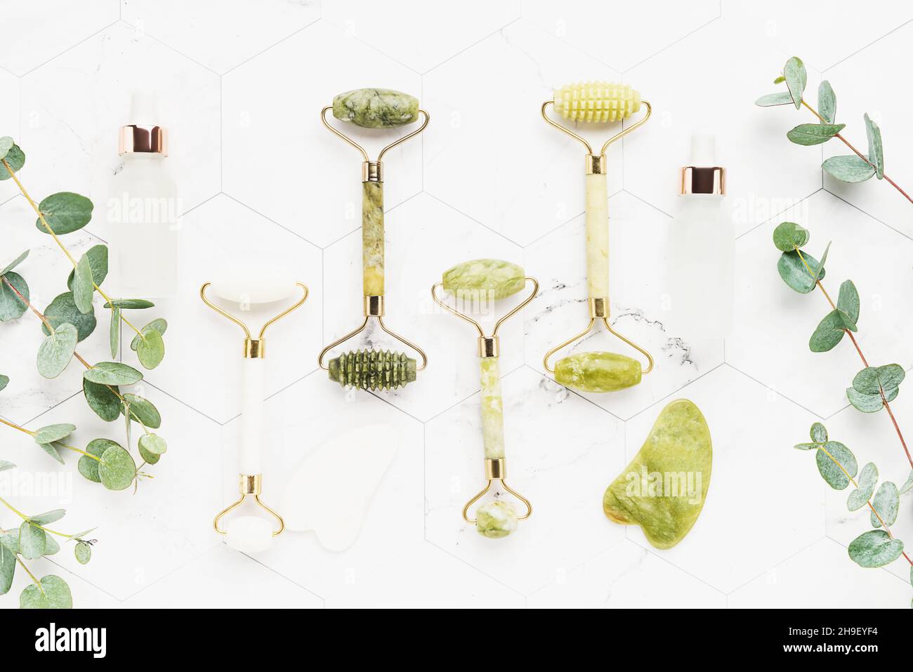 Massage tools. Gua Sha massager, jade facial rollers and eucalyptus