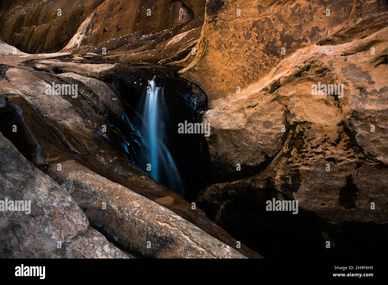 Pure, clean water trickles through the sandstone of high mountain cliffs.  The sandstone creates a natural filtration system. Stock Photo