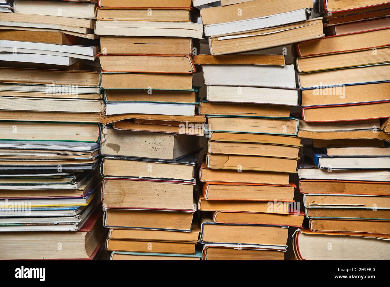 Wall of books piled up Stock Photo