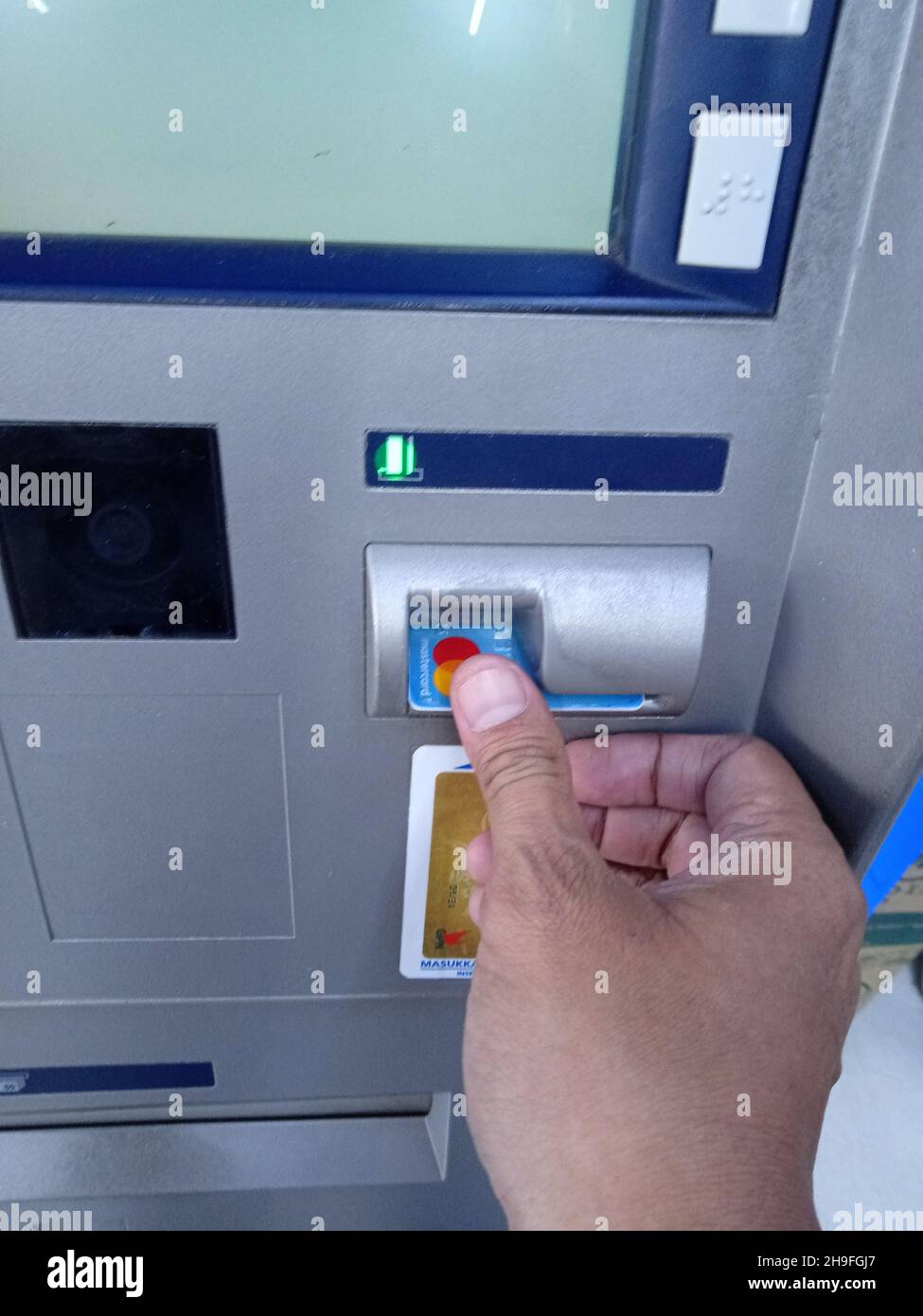 Editorial Photo, Indonesia, East Jakarta, 02 October 2021, Man Inserting Card at ATM BCA Stock Photo