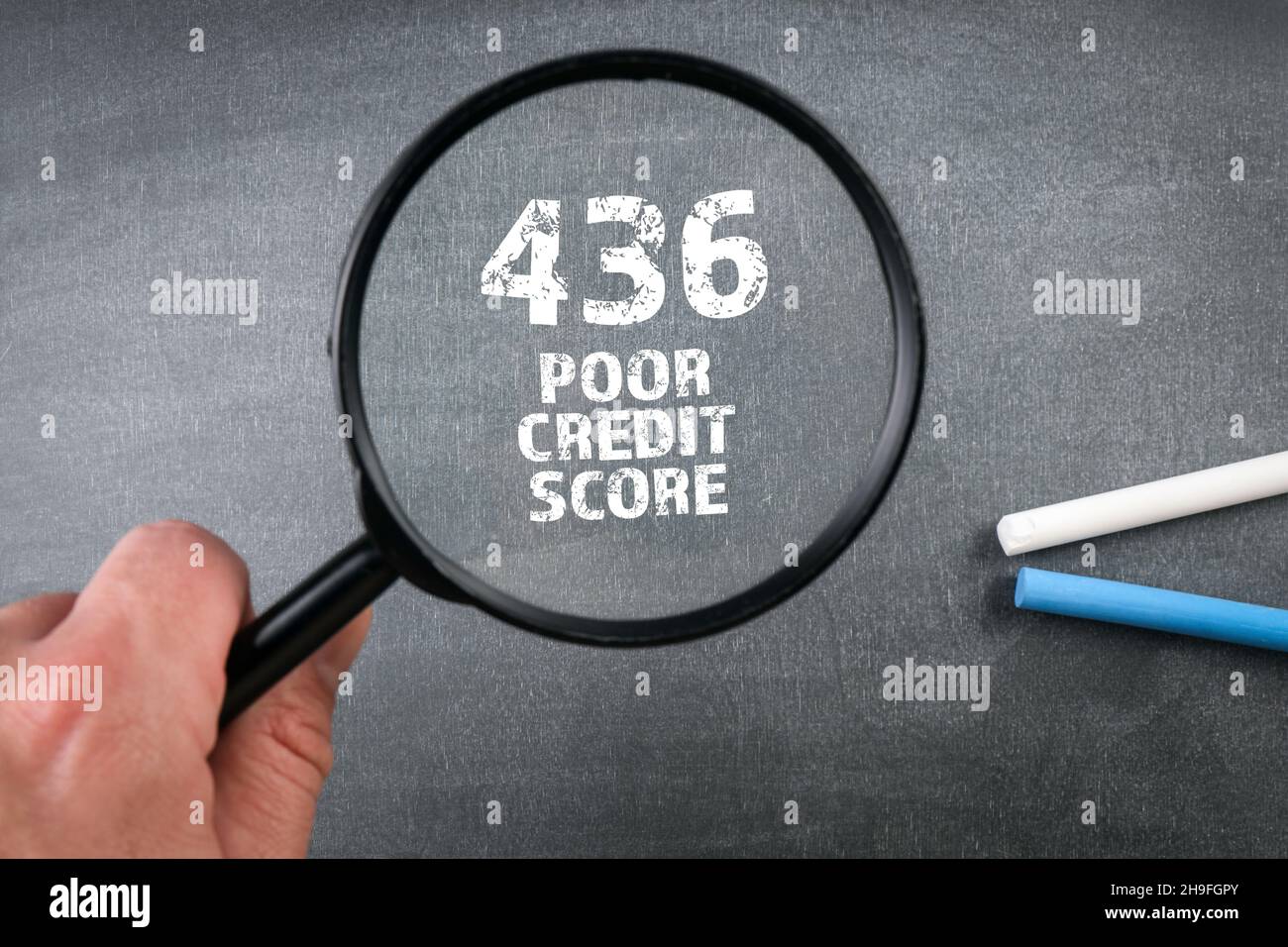 Poor Credit Score. Magnifying glass on a chalk board. Stock Photo