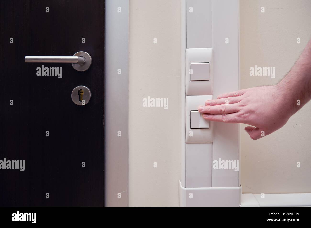 Man hand turns off the light with a switch in the office room Stock ...
