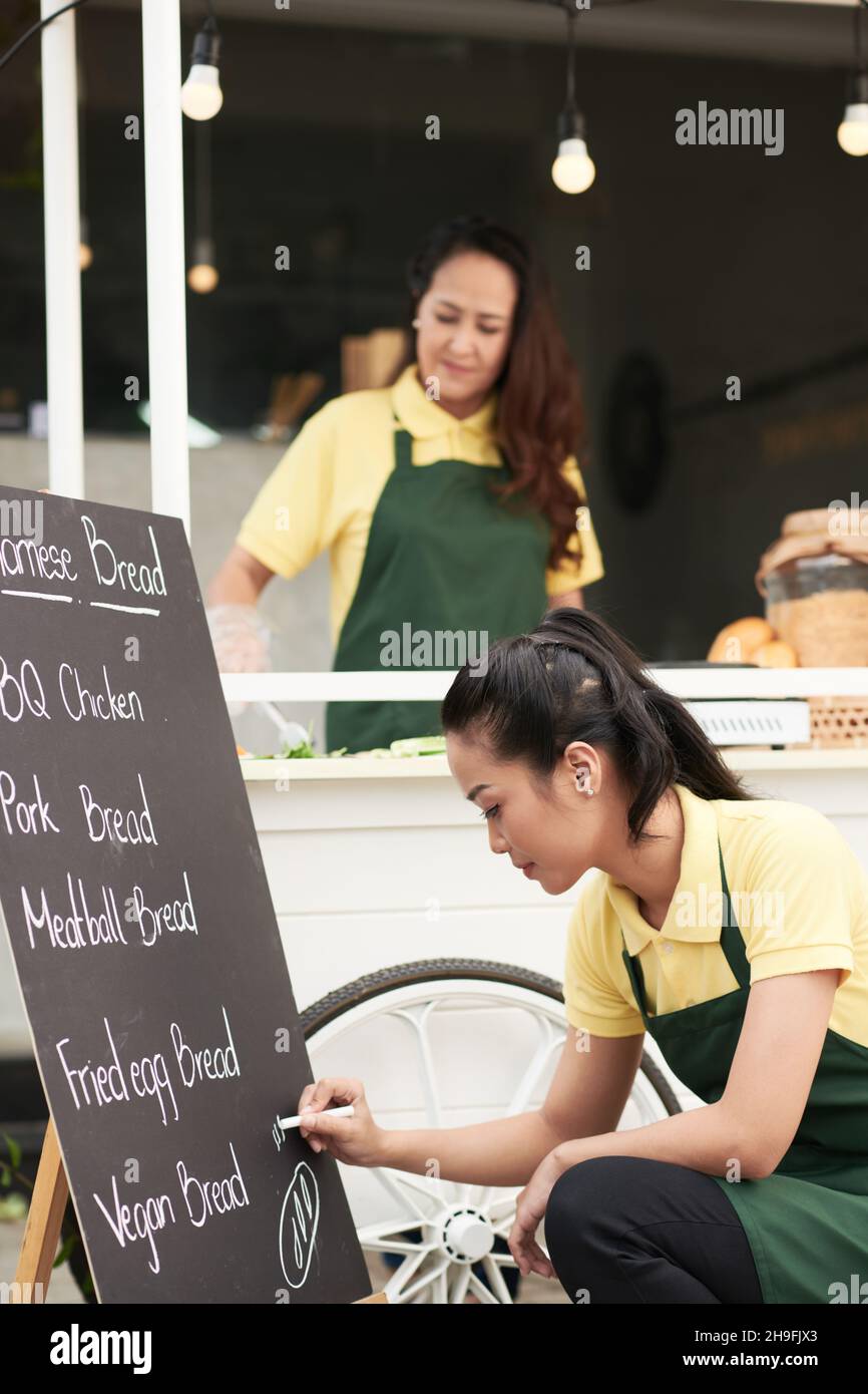 Street food cart owners preparing for the day of work, cutting