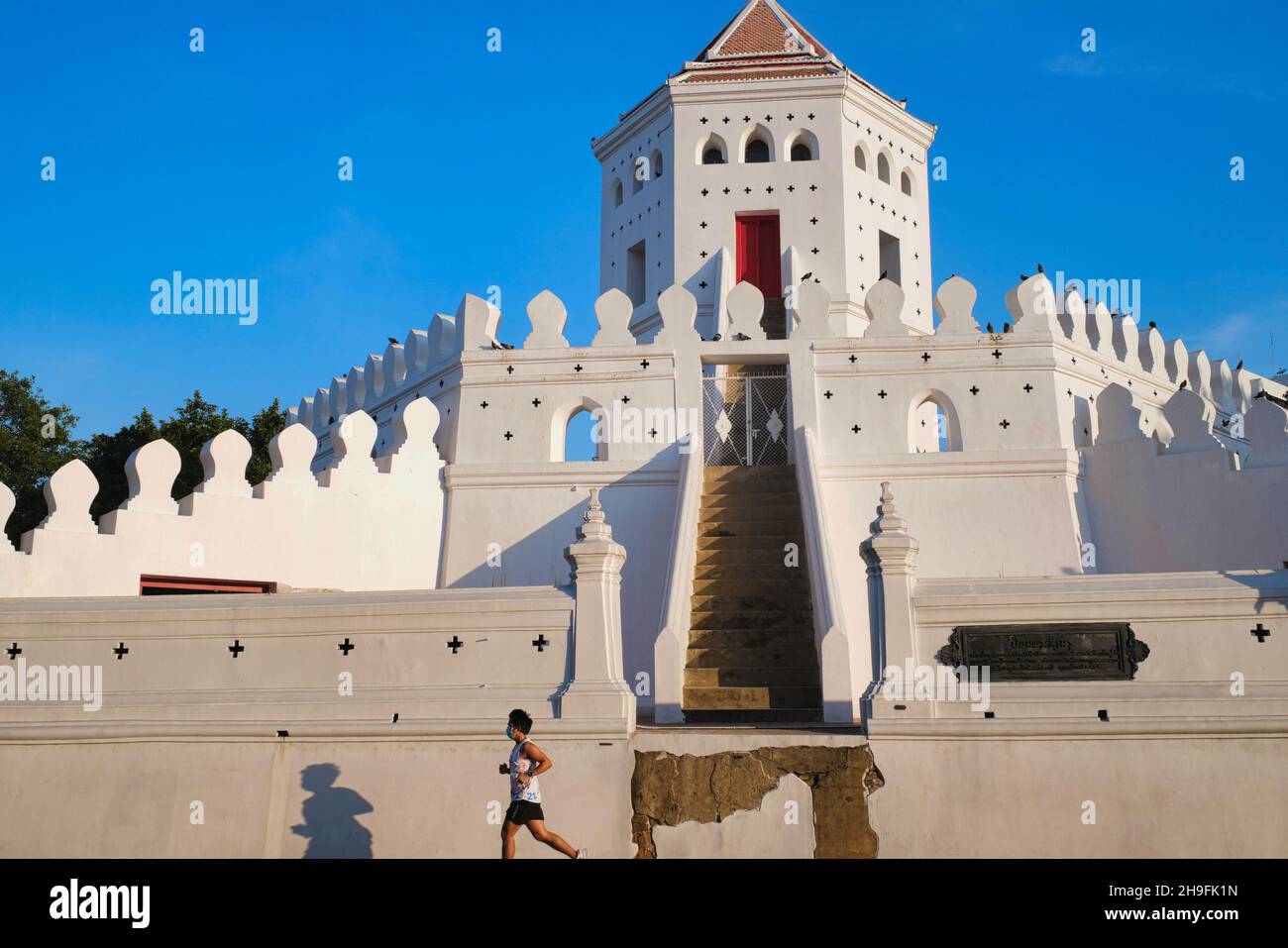 A jogger runs past Phra Sumen Fort, a small fort, part of a former city wall  in Santichaiprakan Park, Phra Arthit Rd.,Banglamphoo, Bangkok, Thailand Stock Photo