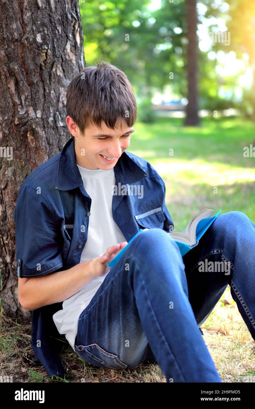 Guy reading book under tree hi-res stock photography and images - Alamy