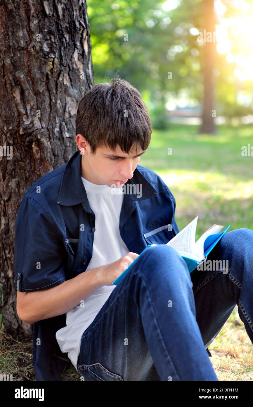 Guy reading book under tree hi-res stock photography and images - Alamy