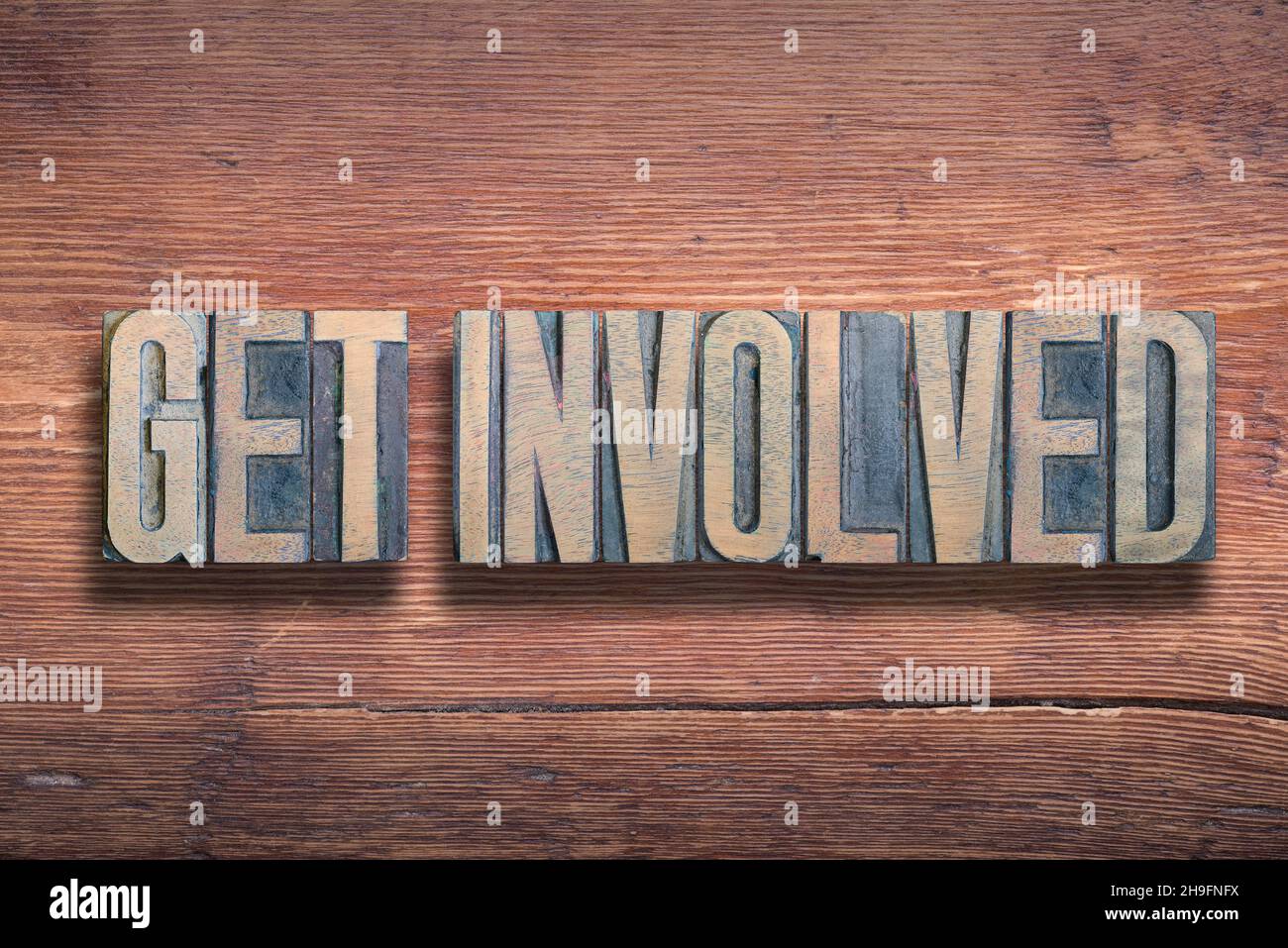 get involved phrase combined on vintage varnished wooden surface Stock Photo