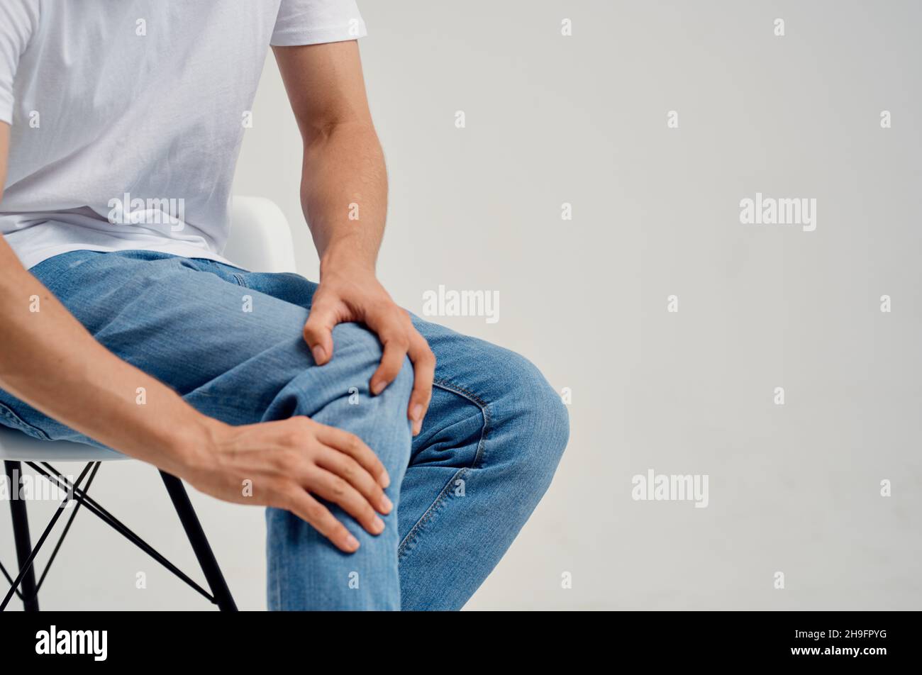 Man sitting on chair knee pain health problems Stock Photo Alamy