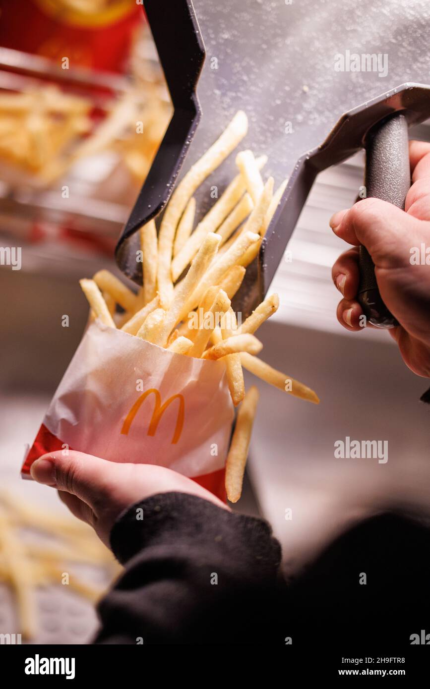 Munich, Germany. 02nd Dec, 2021. An employee fills a bag with French fries at a branch of the McDonald's fast food chain on Martin-Luther-Strasse in Giesing. The branch opened its doors on 4 December 1971 as the first McDonald's branch in Germany. Credit: Matthias Balk/dpa/Alamy Live News Stock Photo