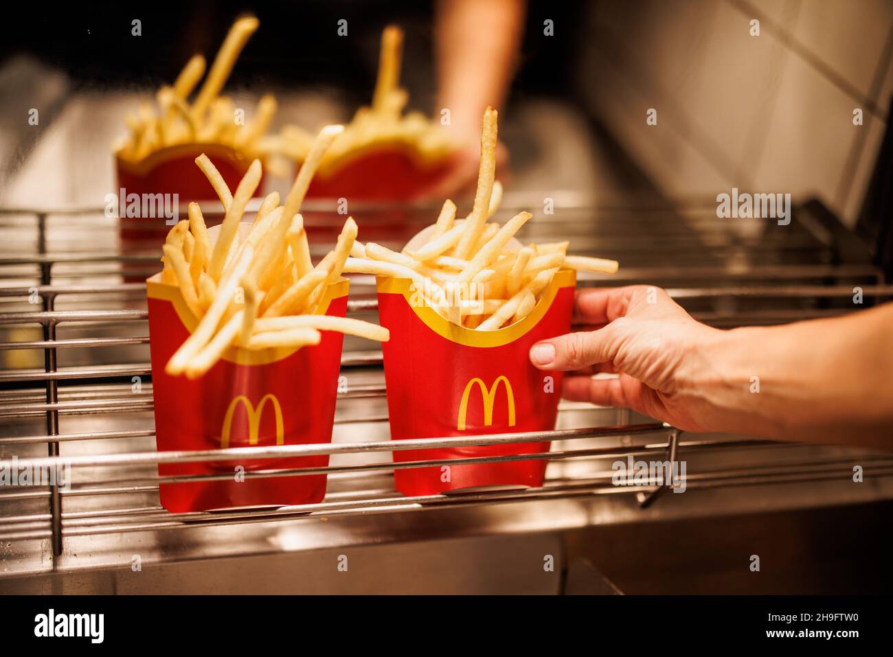 Munich, Germany. 02nd Dec, 2021. An employee places a bag of French fries in a grid at a branch of the McDonald's fast food chain on Martin-Luther-Strasse in Giesing. The branch opened its doors on 4 December 1971 as the first McDonald's branch in Germany. Credit: Matthias Balk/dpa/Alamy Live News Stock Photo