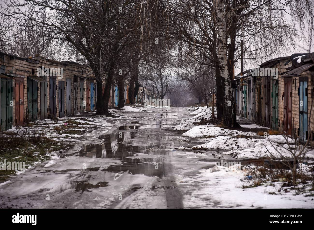 puddle of melted white snow on a cloudy spring day.  Stock Photo