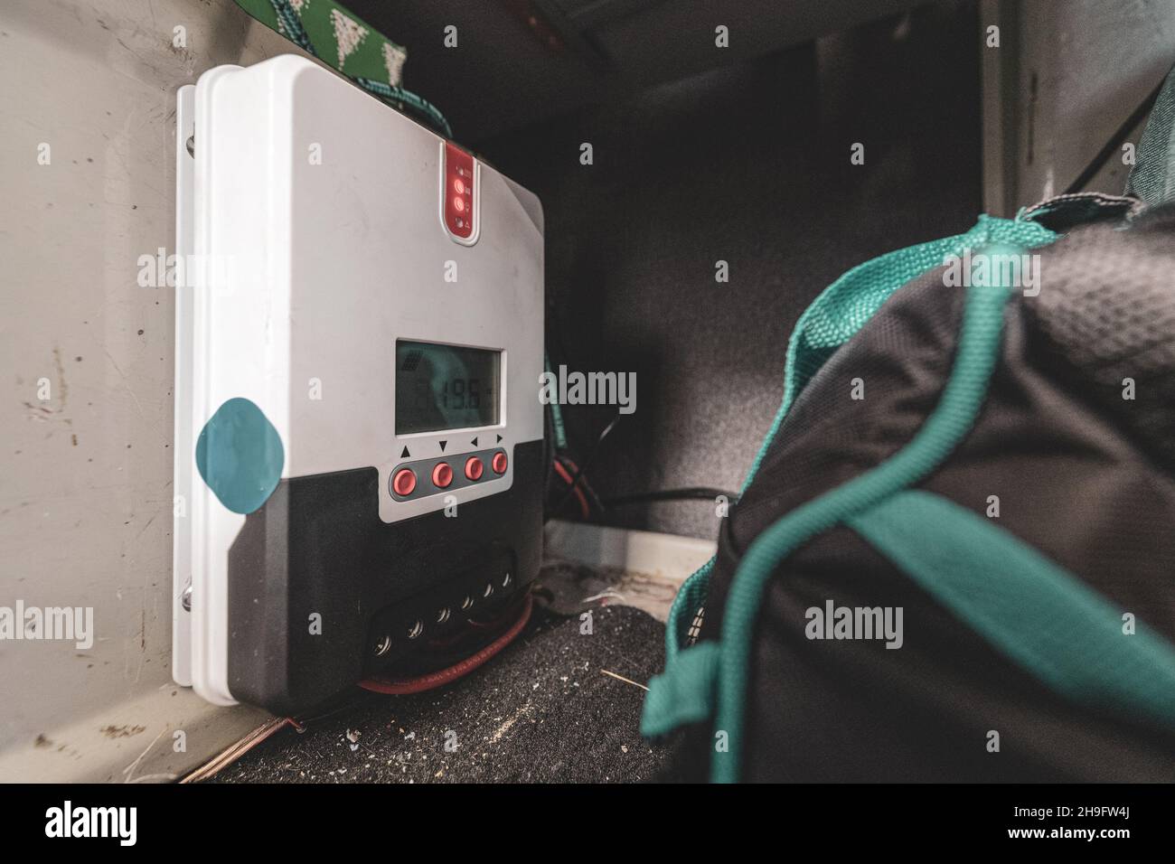 MPPT Solar charge controller installed in a van or camper truck somewhere under the cupboard cabinet. Stock Photo