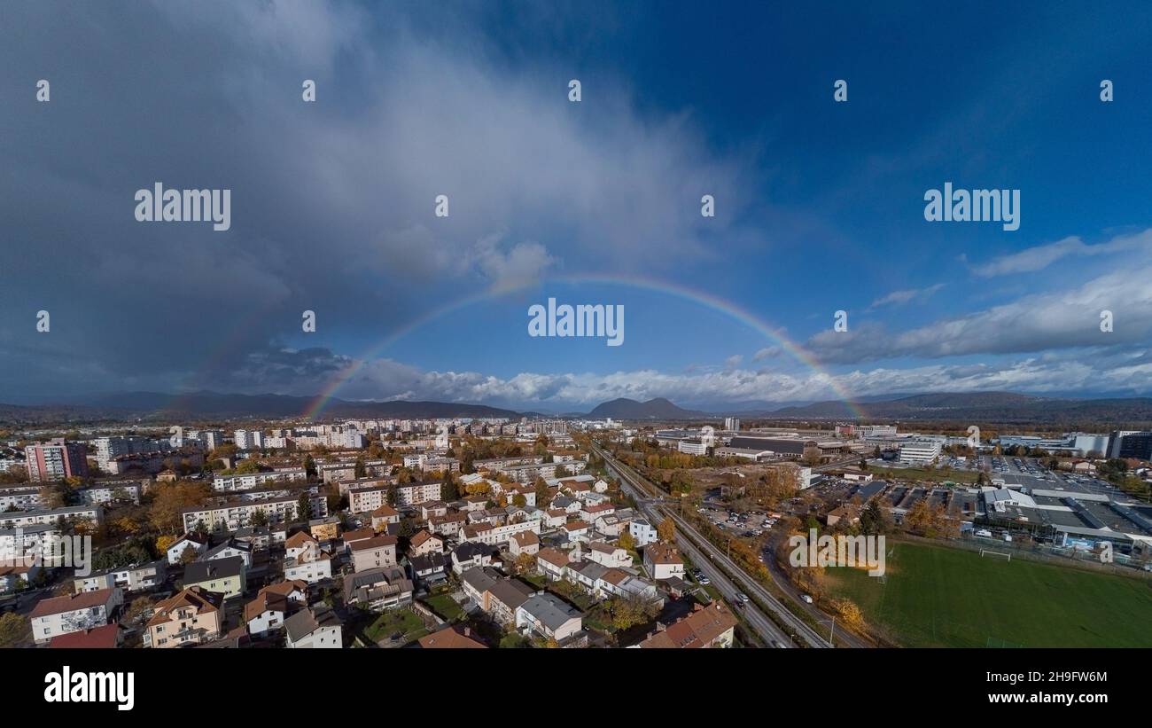 Panorama of siska district in Ljubljana, Slovenia accompanied by beautiful rainbow spanning over the horison over the Smarna Gora mouintain. Dreamy ph Stock Photo