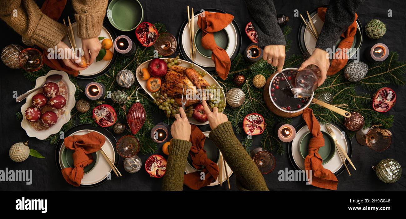 People feasting with chicken and hot wine at table Stock Photo