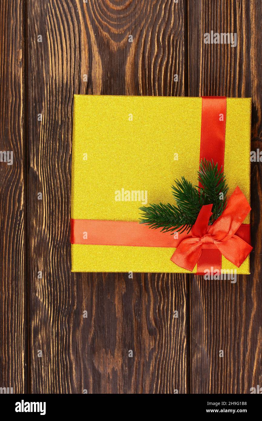 Christmas layout on a wooden background. Gold glitter box with bow and winter toys. Top view, flat style. Stock Photo