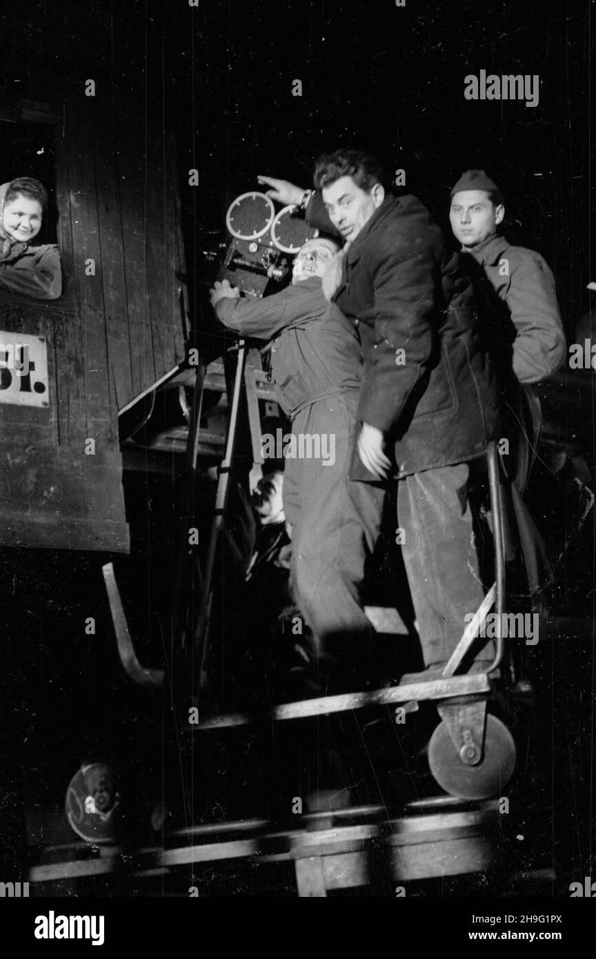 Bytom, 1948-04. Holenderski re¿yser, dokumentalista Yoris Yvens krêci w Polsce film o pracy robotników. Pomagaj¹ mu pracownicy przedsiêbiorstwa Film Polski i Polskiej Kroniki Filmowej (PKF). Plan zdjêciowy w hucie Bobrek. Nz. Yoris Yvens (2P), operatorzy PKF: W³adys³aw Forbert (3P) i Mieczys³aw Wiesio³ek (1P), filmuj¹ pracownicê zak³adu. wb  PAP  Dok³adny dzieñ wydarzenia nieustalony.      Bytom, April 1948. Dutch director of documentary movies Yoris Yvens films Polish workers. He is assisted by Polish Film and Polish Newsreel employees (PKF). Pictured: on location filming at Bobrek steelwork, Stock Photo