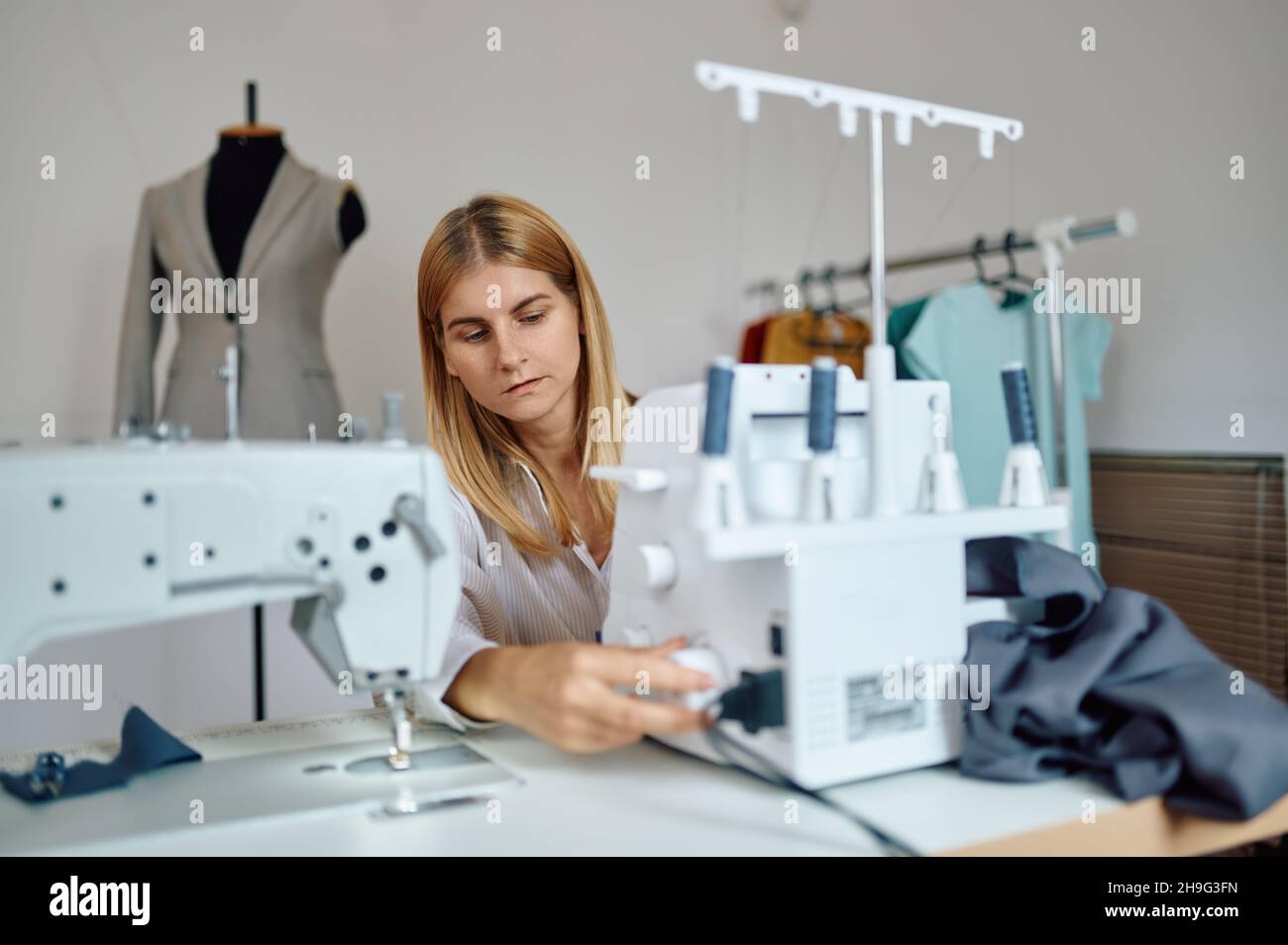 Dressmaker works on sewing machine at workplace Stock Photo - Alamy