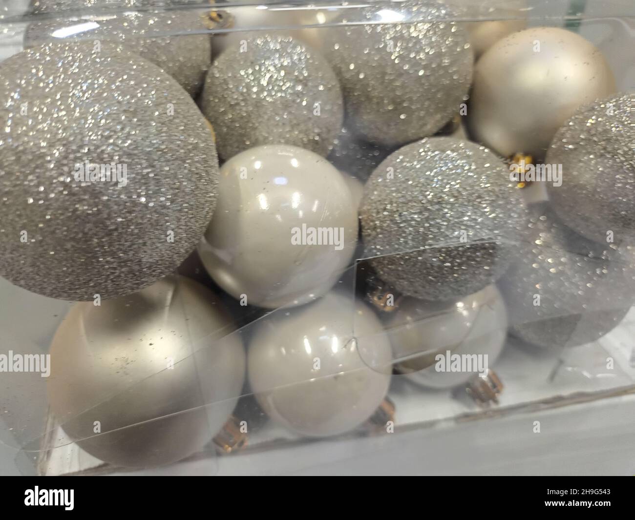 Silver Christmas balls in transparent plastic box. shiny sparkling new year background. Stock Photo