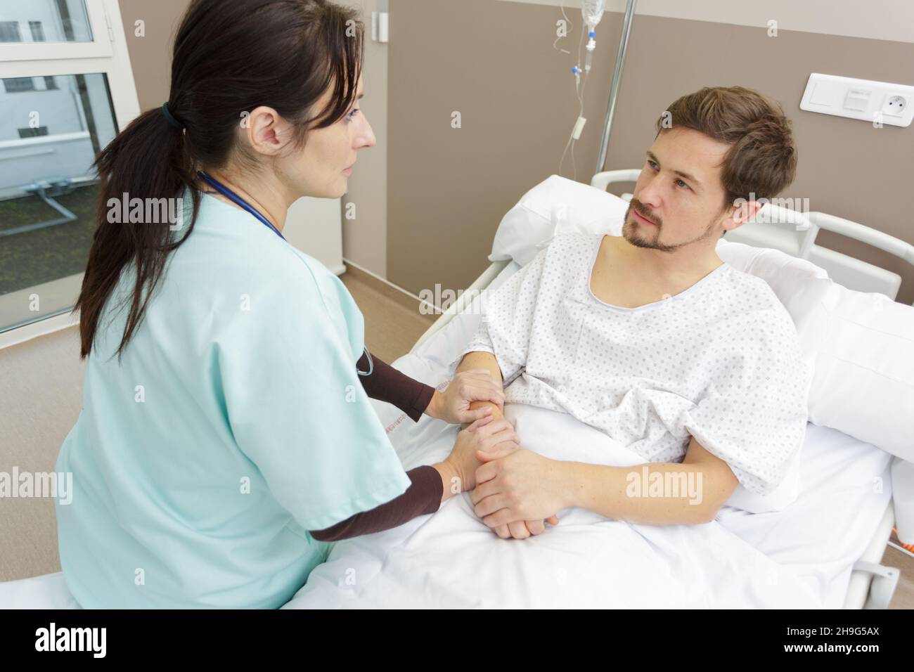 male patient getting examined in hospital room by female nurse Stock ...