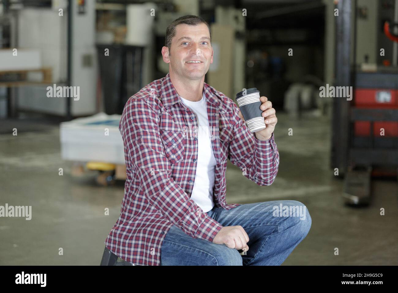 handsome cargo worke drinking coffee on a disposable cup Stock Photo