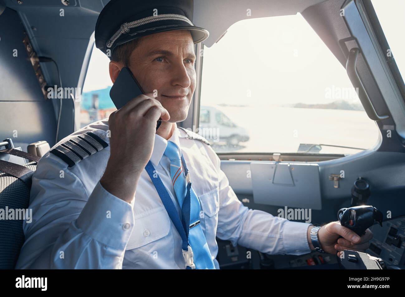Pilot in command calling someone from cockpit Stock Photo Alamy