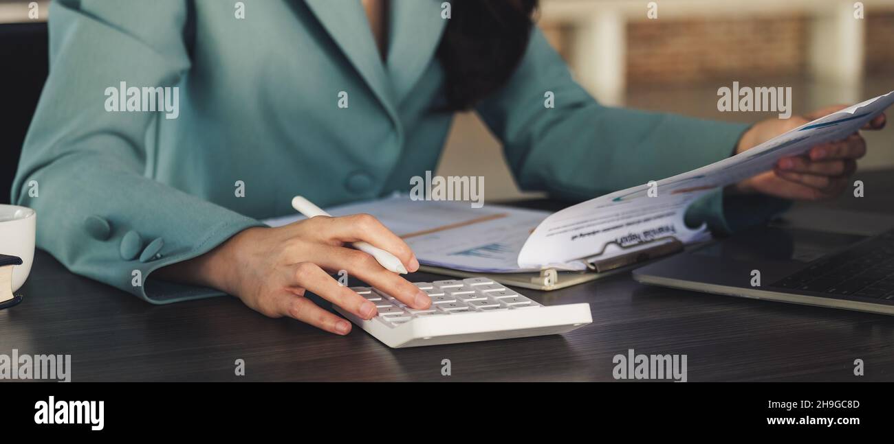 Close up asian accountant working and analyzing financial reports project accounting with chart graph and calculator Stock Photo